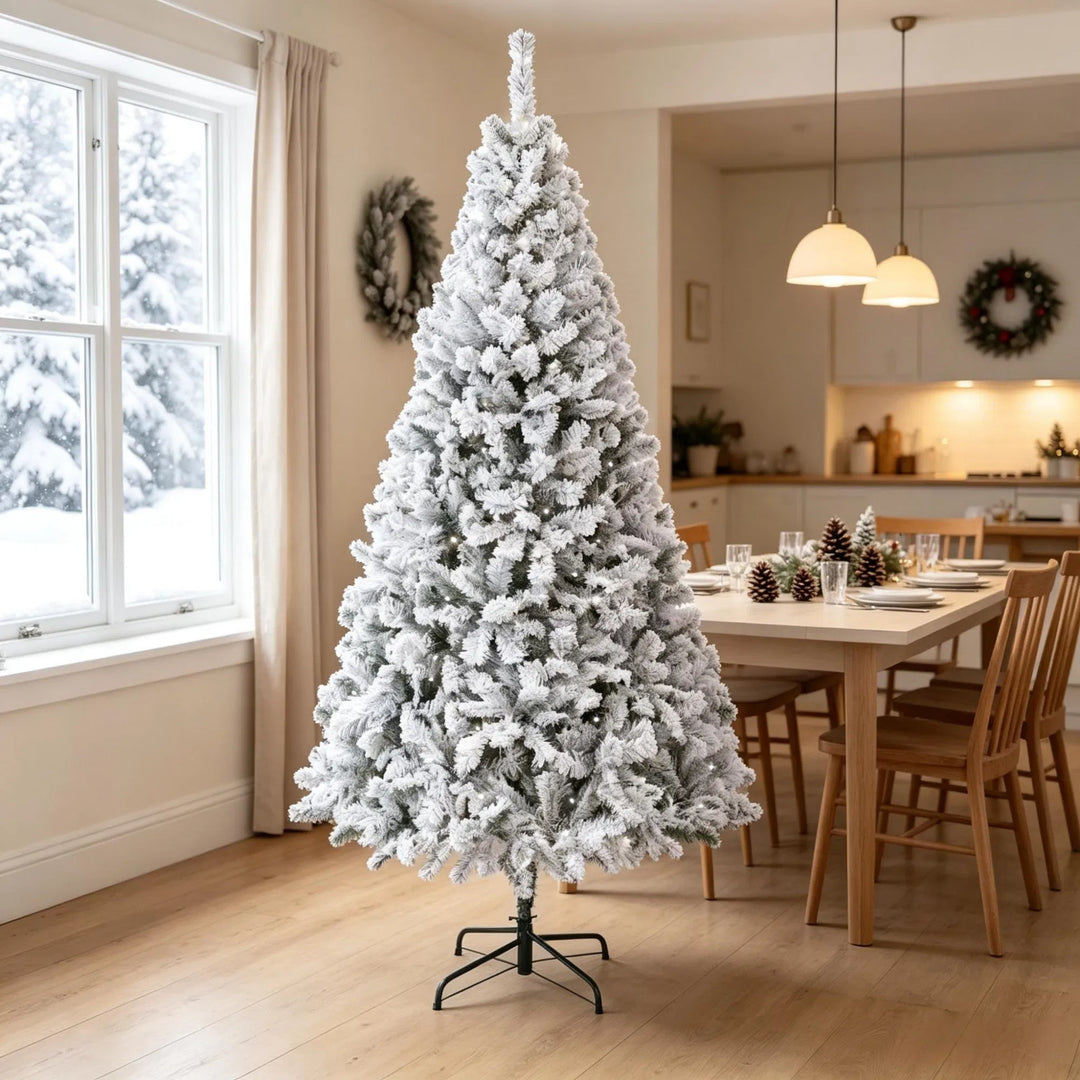 Snöflockad gran med varmvita ljus