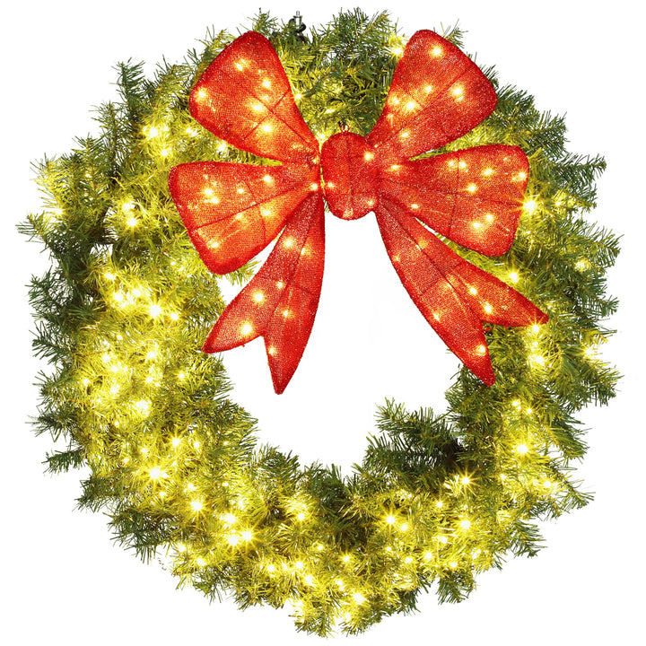 Stor belyst julkrans med röd rosett