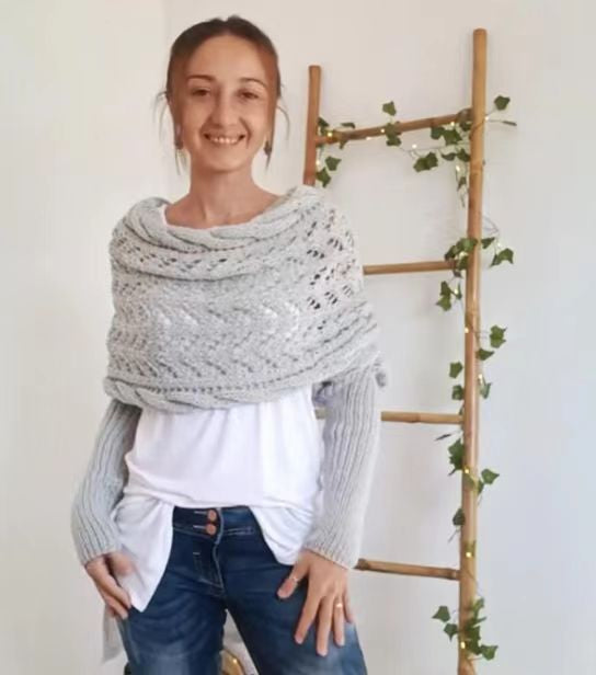 Kvinna i stickad ljusgrå sjal med ärmar