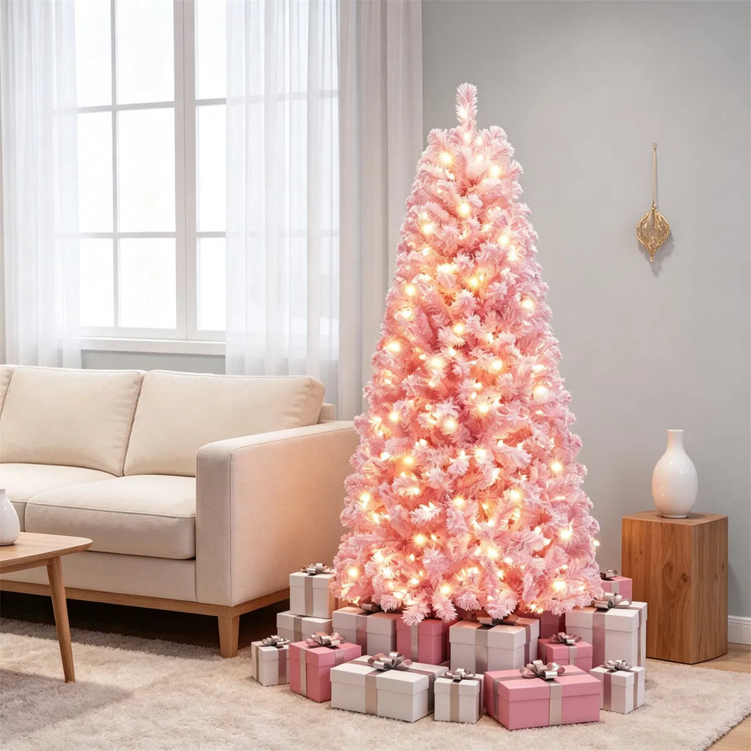 Liten rosa flockad julgran med ljus
