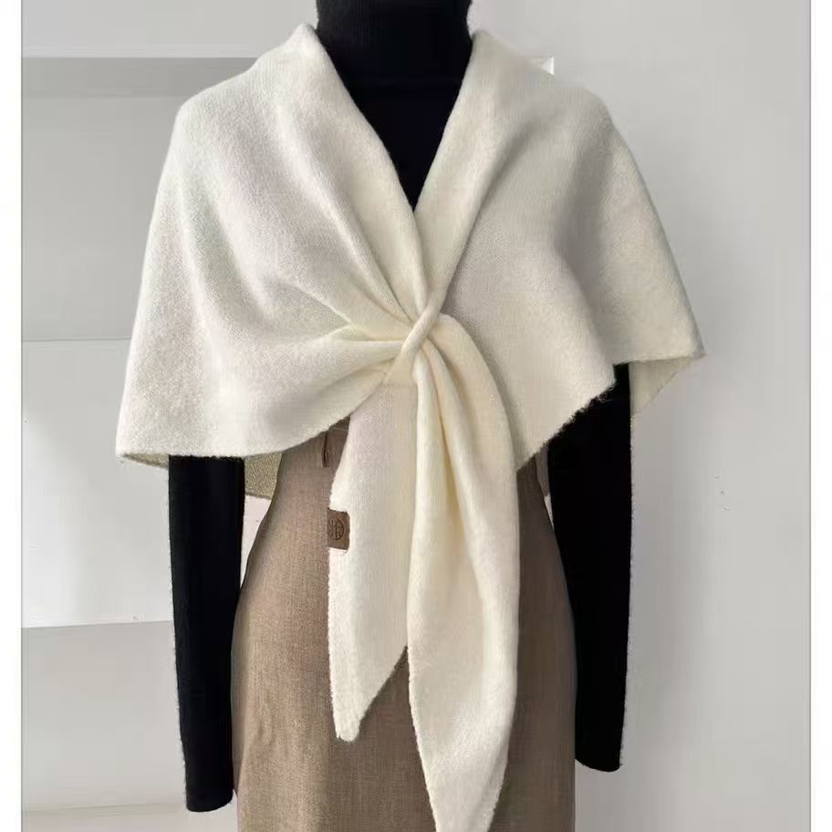 Kvinna med knuten trekantsjal i ljusgrå ull
