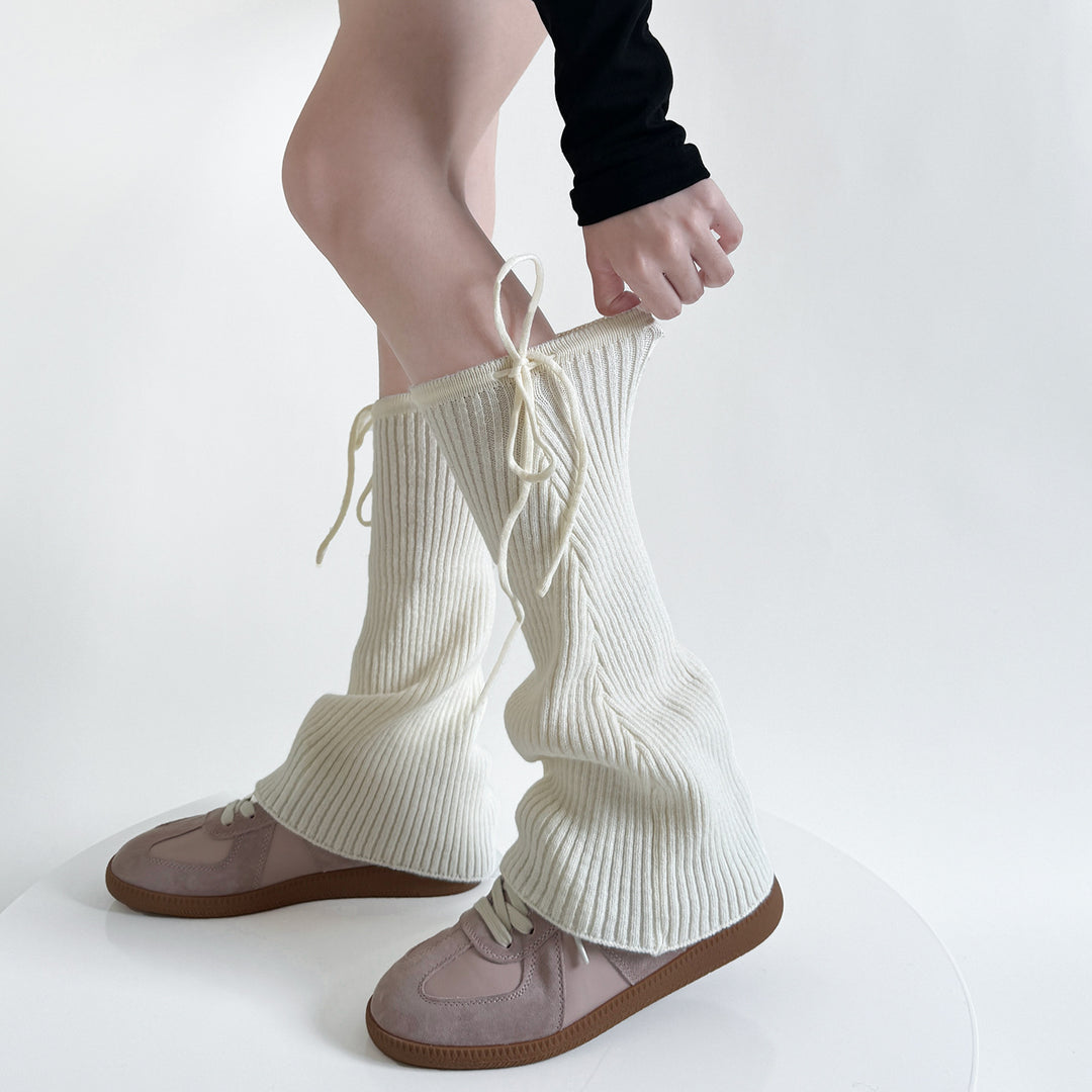Ribbstickade benvärmare med knytband i beige