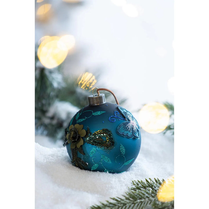 Fyra petrolblå julkulor i glas med glitter