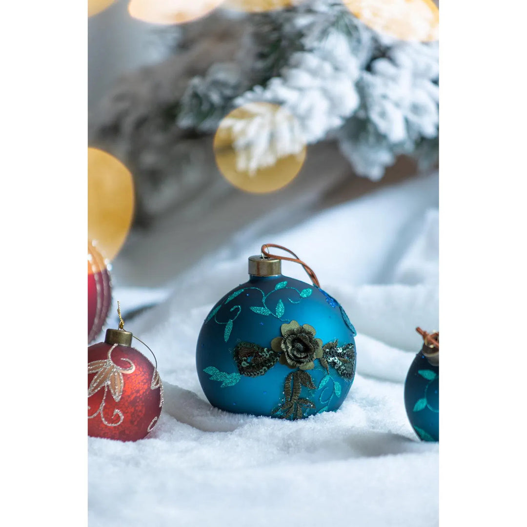 Fyra petrolblå julkulor i glas med glitter