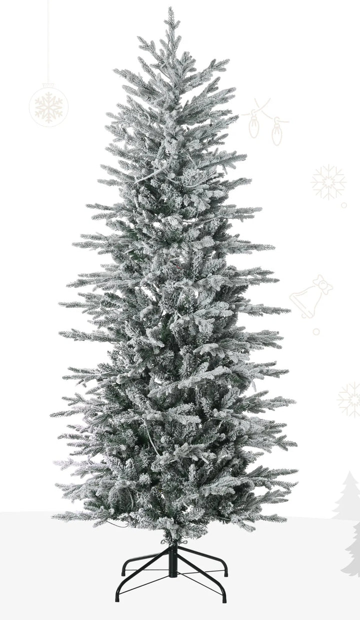Snöflockad julgran med klara ljus