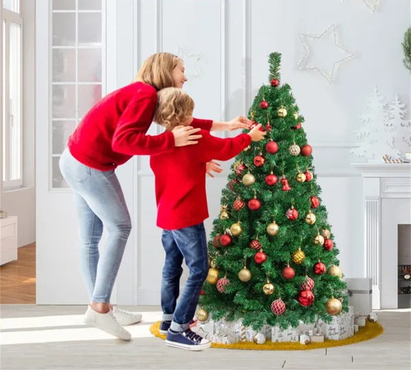 Liten grön konstgjord julgran på metallfot