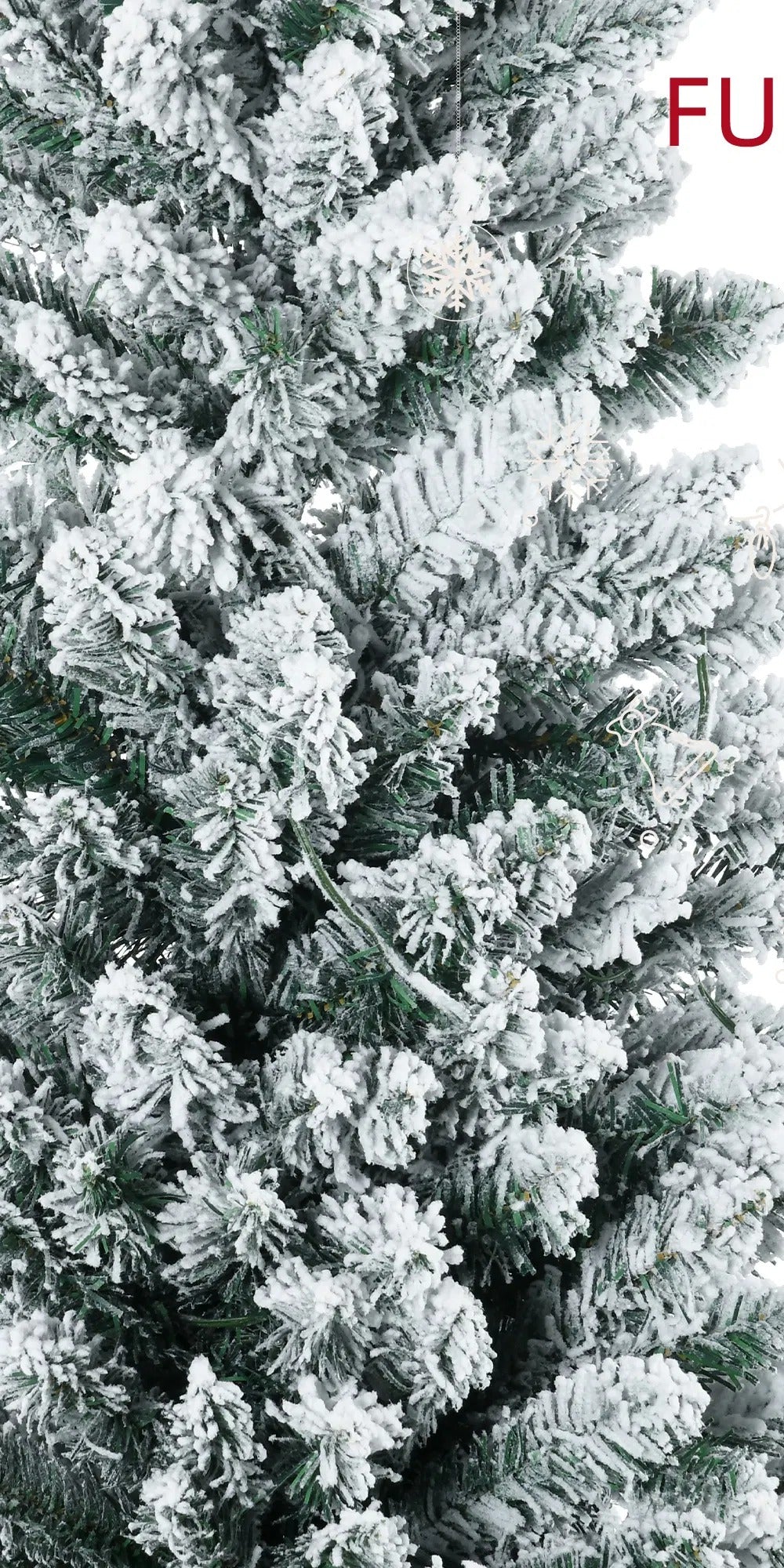 Snöig smal julgran med varma ljus