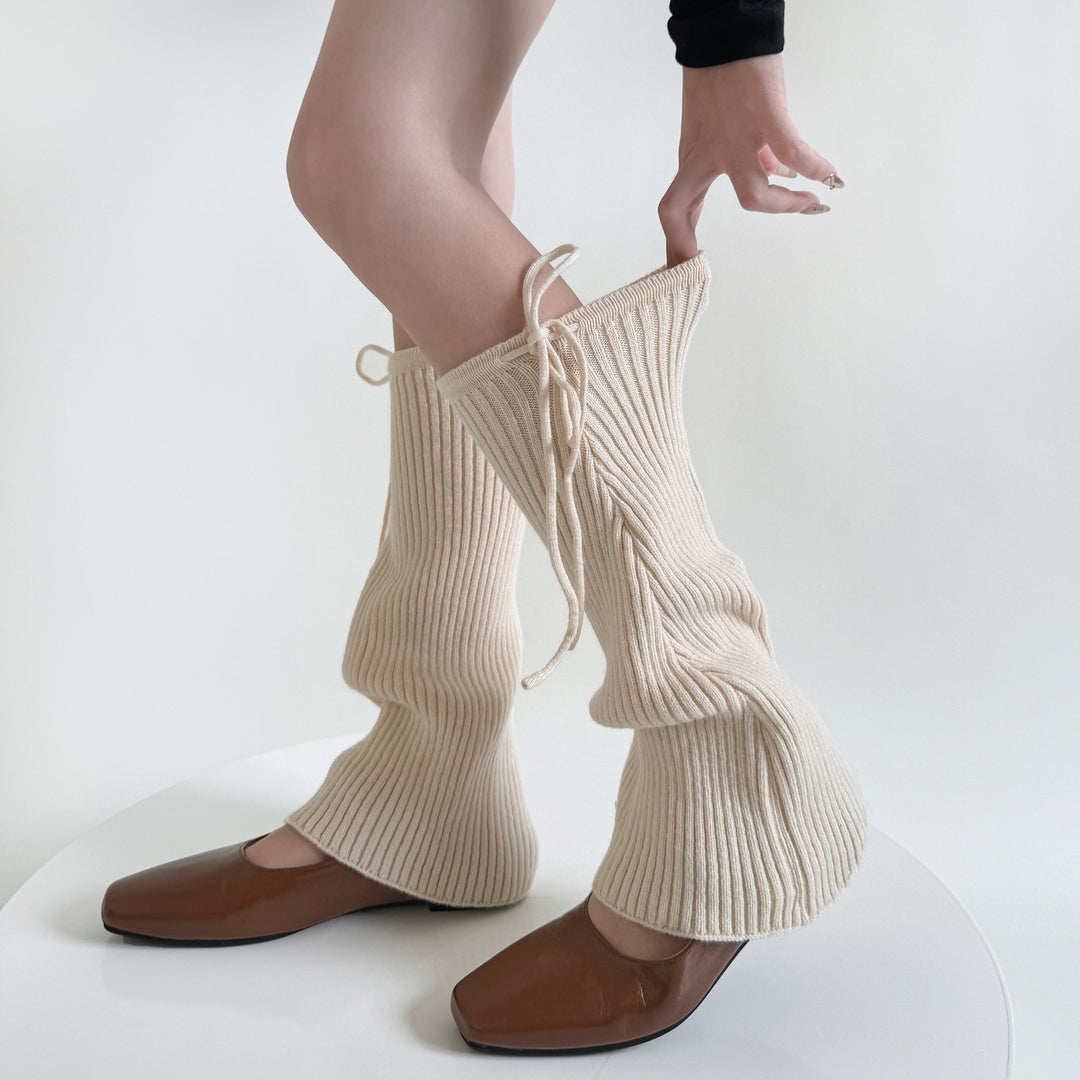 Ribbstickade benvärmare med knytband i beige