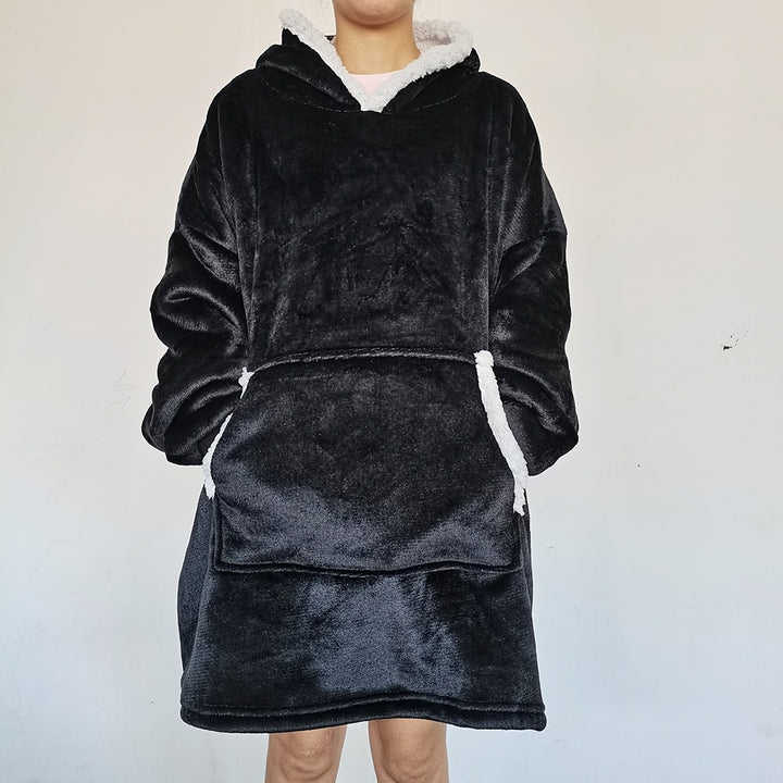 Person i oversize hoodiefilt med huva