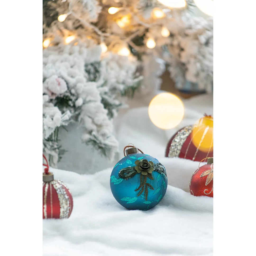 Fyra petrolblå julkulor i glas med glitter