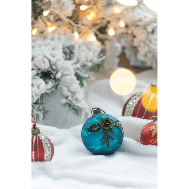 Fyra petrolblå julkulor i glas med glitter