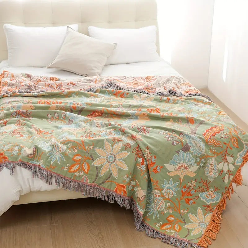 Blommig boho-filt i bomull med fransar i orange och blått