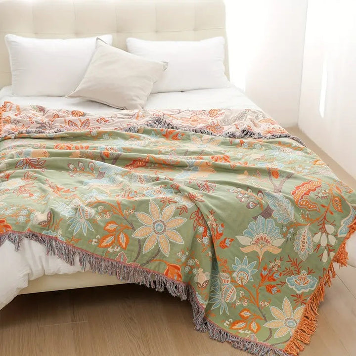 Blommig boho-filt i bomull med fransar i orange och blått